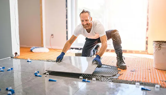 Professional flooring contractor installing hardwood floor in a residential home.