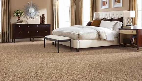 Cozy bedroom with soft beige carpet flooring, stylish furniture, and warm natural lighting.