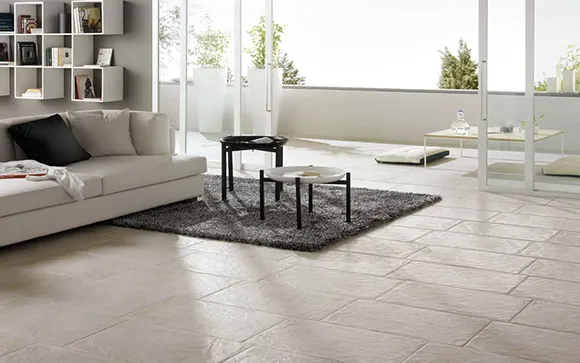 Modern living room with large light ceramic tile flooring and minimalist furniture.