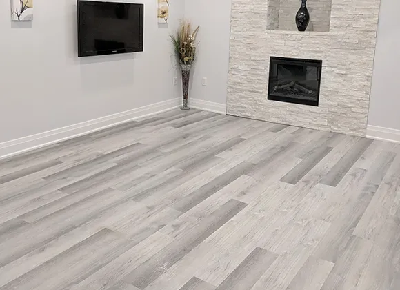 Modern living space showcasing light gray luxury vinyl plank flooring with clean minimal decor.