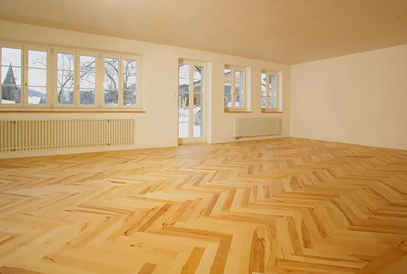 Spacious room featuring bright laminate flooring arranged in stylish herringbone pattern.