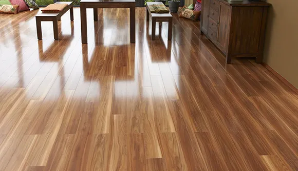 Room with polished medium brown laminate flooring reflecting natural light from large windows.