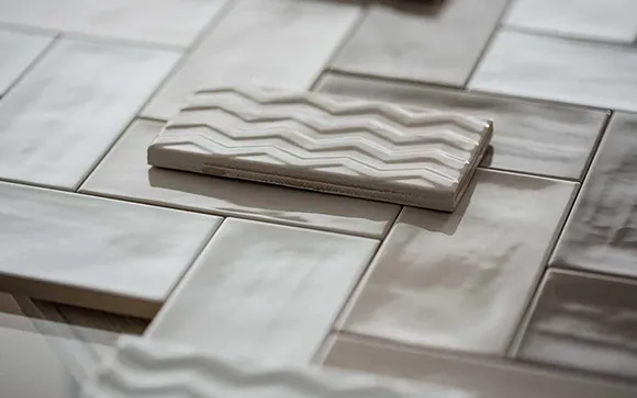 Close-up of textured ceramic floor tiles in various neutral shades arranged for installation.