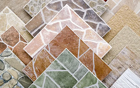 Assorted colorful ceramic tiles displayed in overlapping patterns, showcasing diverse textures and designs.