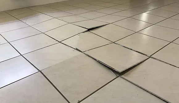 Close-up of cracked and damaged ceramic floor tiles in need of repair in Troy MI.