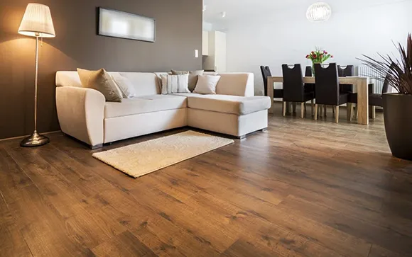 Cozy and bright living room showcasing laminate flooring with neutral sofa and warm lighting.