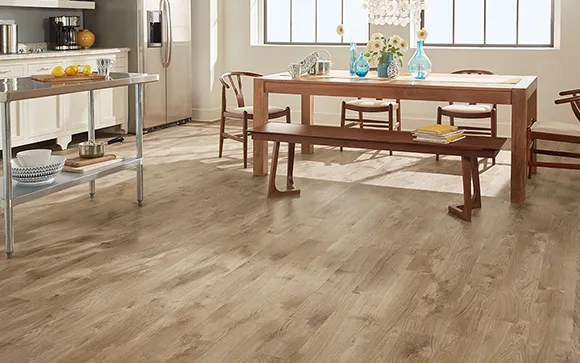 Modern dining room with luxury vinyl plank flooring and wooden table set near a large window.