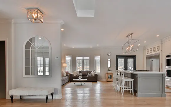 Bright open concept kitchen and living room with polished hardwood flooring.