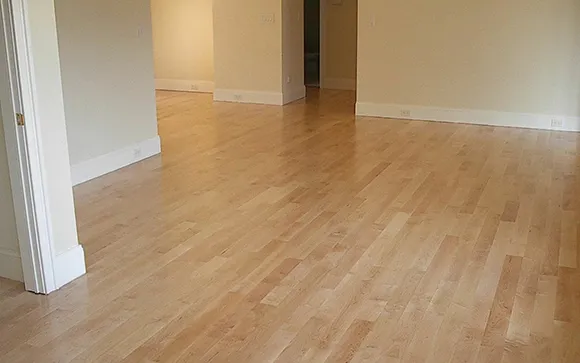 Light brown hardwood flooring installed in a modern empty room with white walls and natural light.