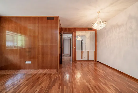 Empty room with freshly installed glossy laminate flooring in Rochester Hills MI home.