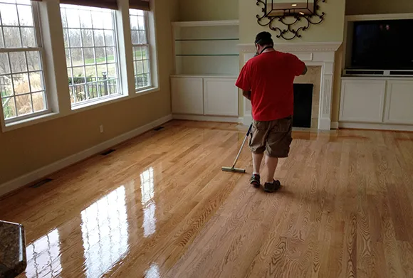 Person barefoot walking on smooth laminate wood flooring.