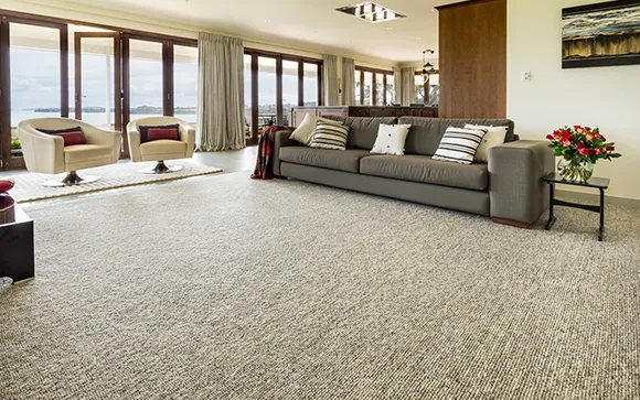 Spacious living room with light beige carpet flooring and large windows in Troy MI.